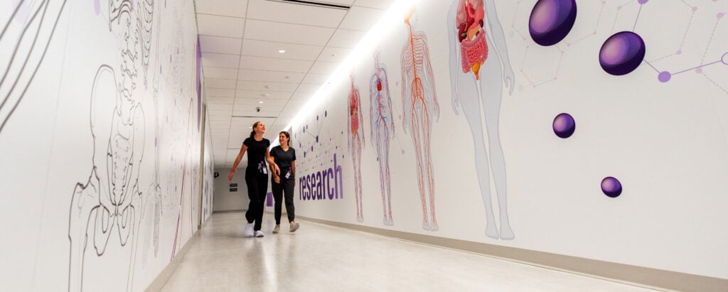 Image of Des Moines University team walking through hallway